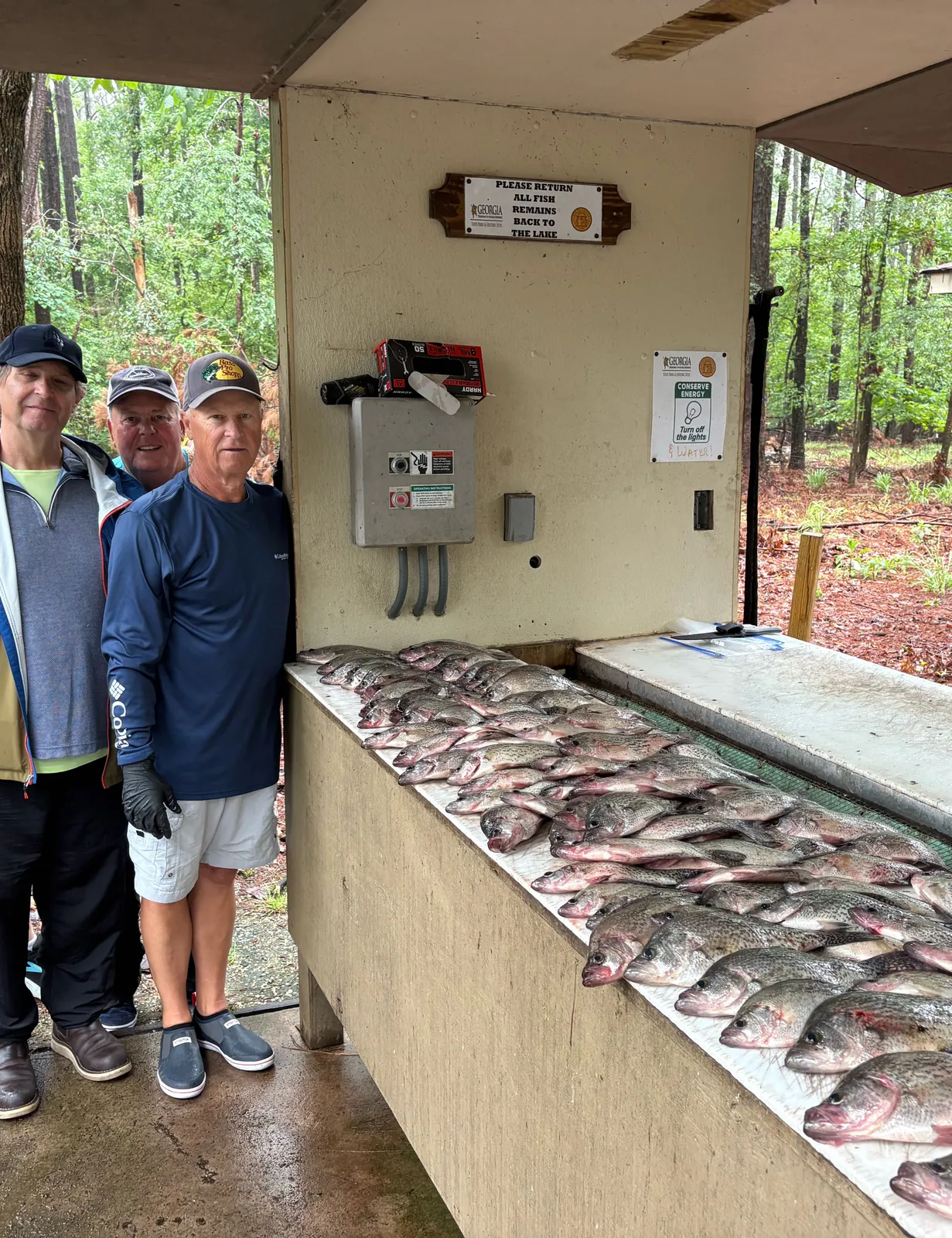 Anglers beside a table covered with freshly caught crappie